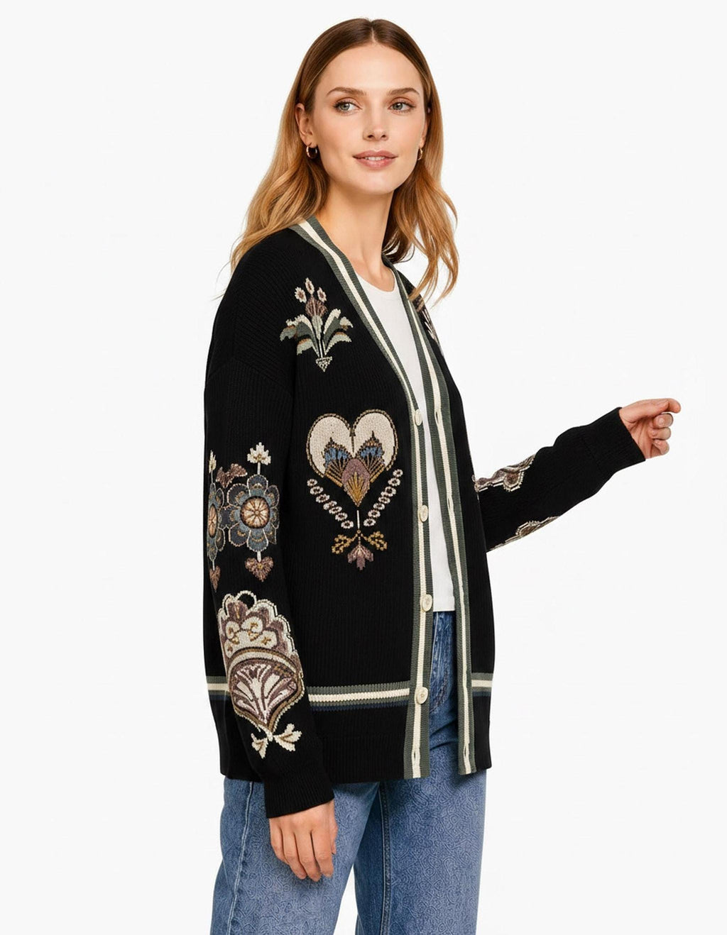 A side profile of the black folk-pattern cardigan, showcasing the detailed knit embroidery on the sleeve and green-trimmed placket.
