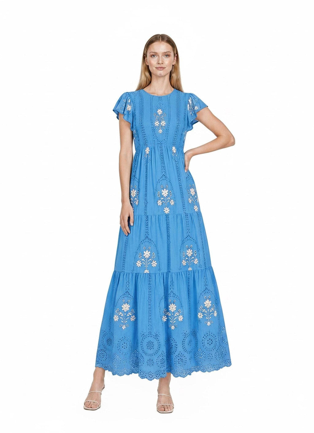 A model posing centered in a bright blue maxi dress featuring tiered sections, flutter sleeves, and intricate white floral embroidery.