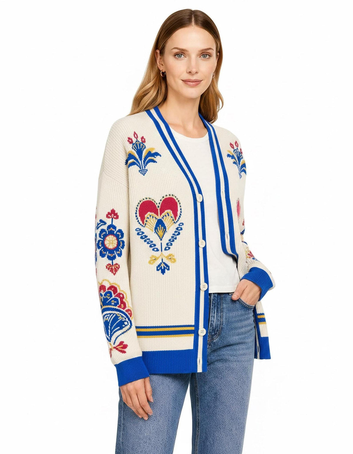 A slightly angled view of the model wearing the ivory and blue folk-pattern cardigan with hands in pockets.