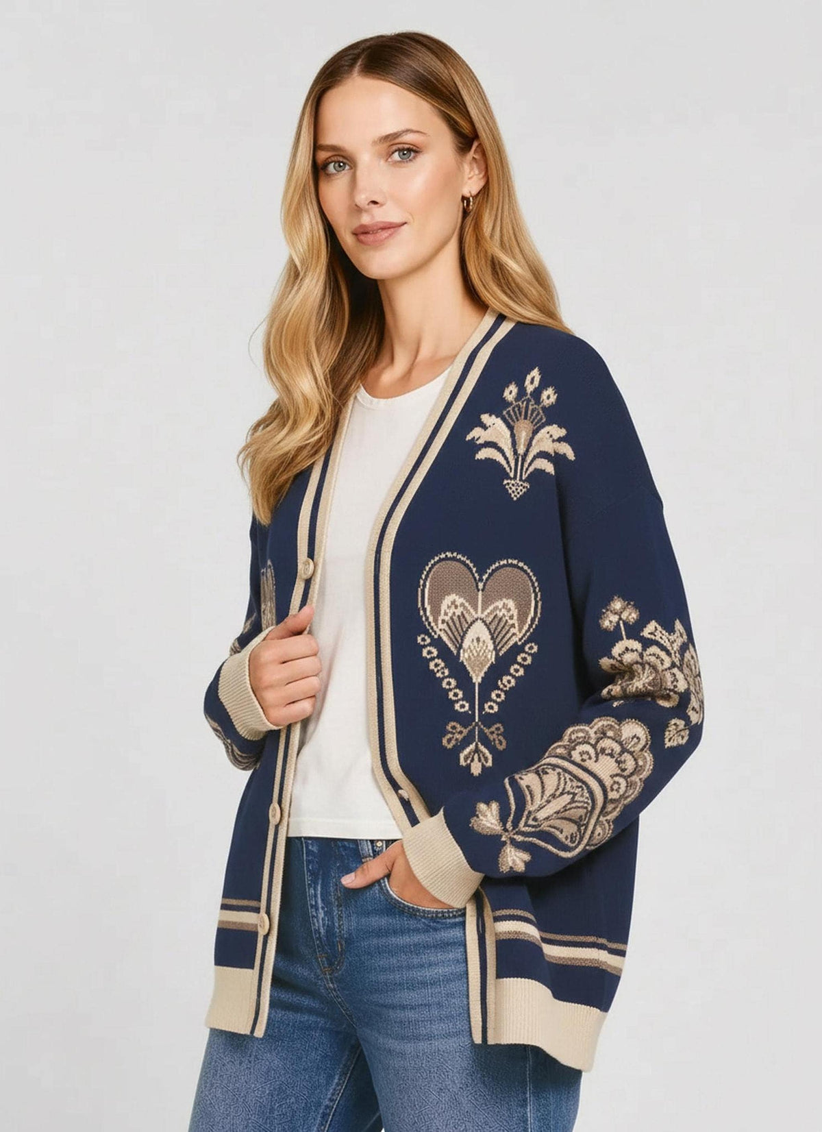 A woman in a dark blue patterned knit cardigan posed with her hand in her pocket, viewed from a slightly turned angle.