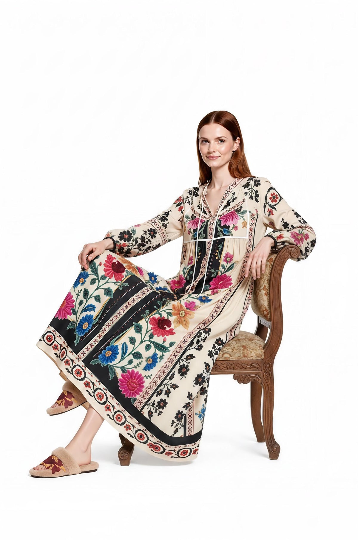 May include: A cream-colored maxi dress featuring long sleeves, a V-neckline with ties, and a vibrant floral pattern in shades of pink, blue, and green. The dress includes black vertical panels and a decorative border along the hemline.